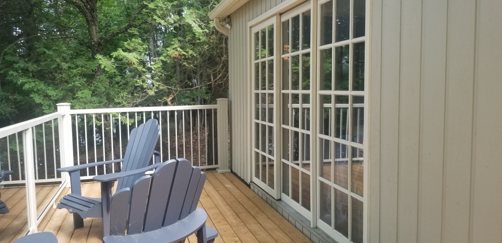 West facing deck. In the sun, the picket railings and posts look like the same colour as the cottage doors trim colour!