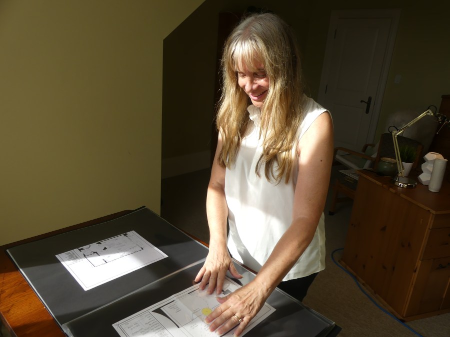 Photo of Lynn Asbury looking at interior design drawings.