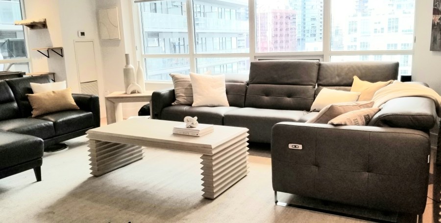 photo shows the condo's living room styled with decor along with new rug, coffee table and console table and side table suggested and redecorated by Lynteriors