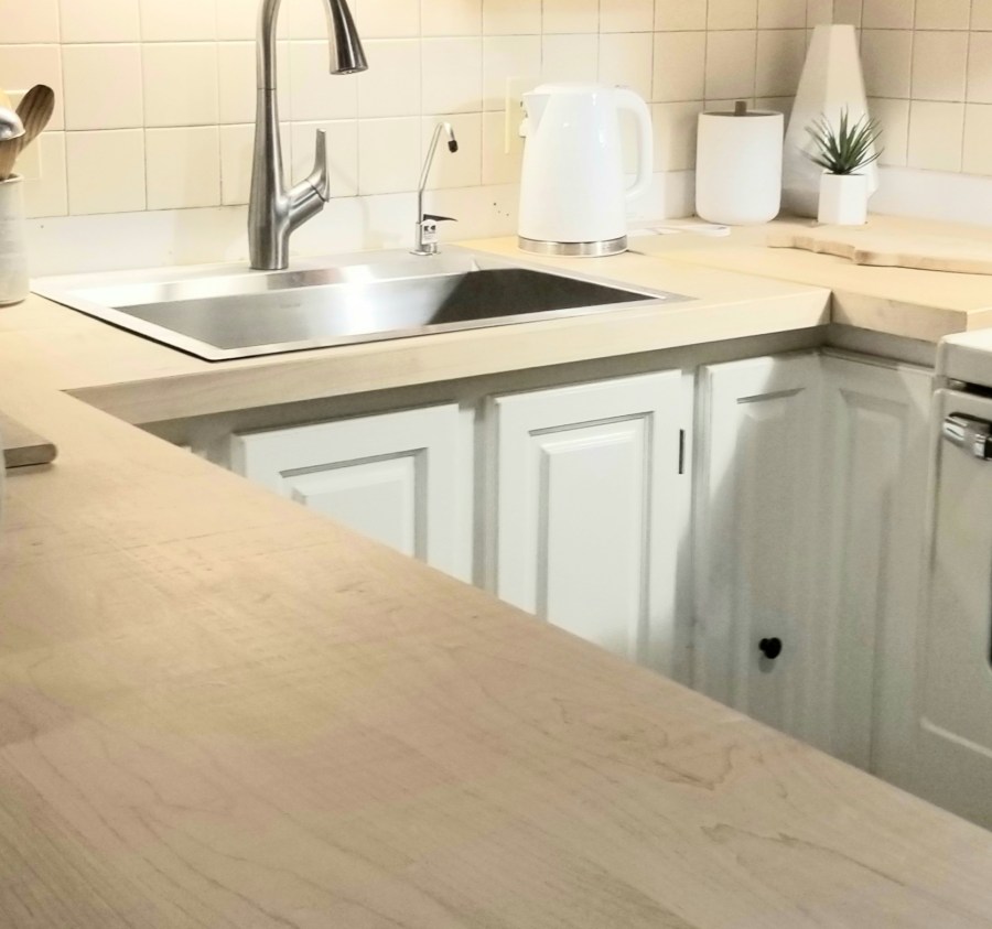 This photo shows the renovated kitchen with a new countertop and refinished cabinets.